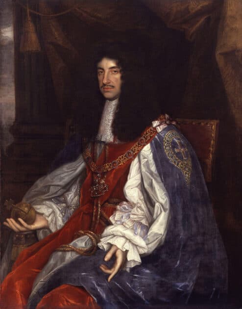 Royal portrait of King Charles I on his throne, dressed in flowing robes of fine silk, and his long curly dark hair resting on his shoulders. He has an expression of calm power and is holding his crown.