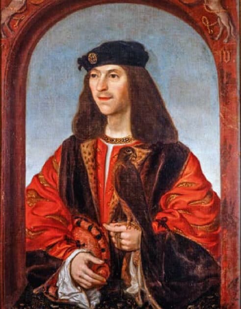 Royal portrait of James IV of Scotland, who poses in red silk robes with a velvet cap, a bird of prey perched on his delicate hands. His royal death in battle was gruesome, but what happened to his corpse is even worse.
